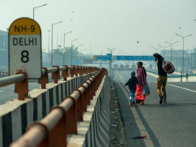 A family walking on an empty road towards Delhi in December 2020, amid farmers' protests against the government's new agricultural reforms.