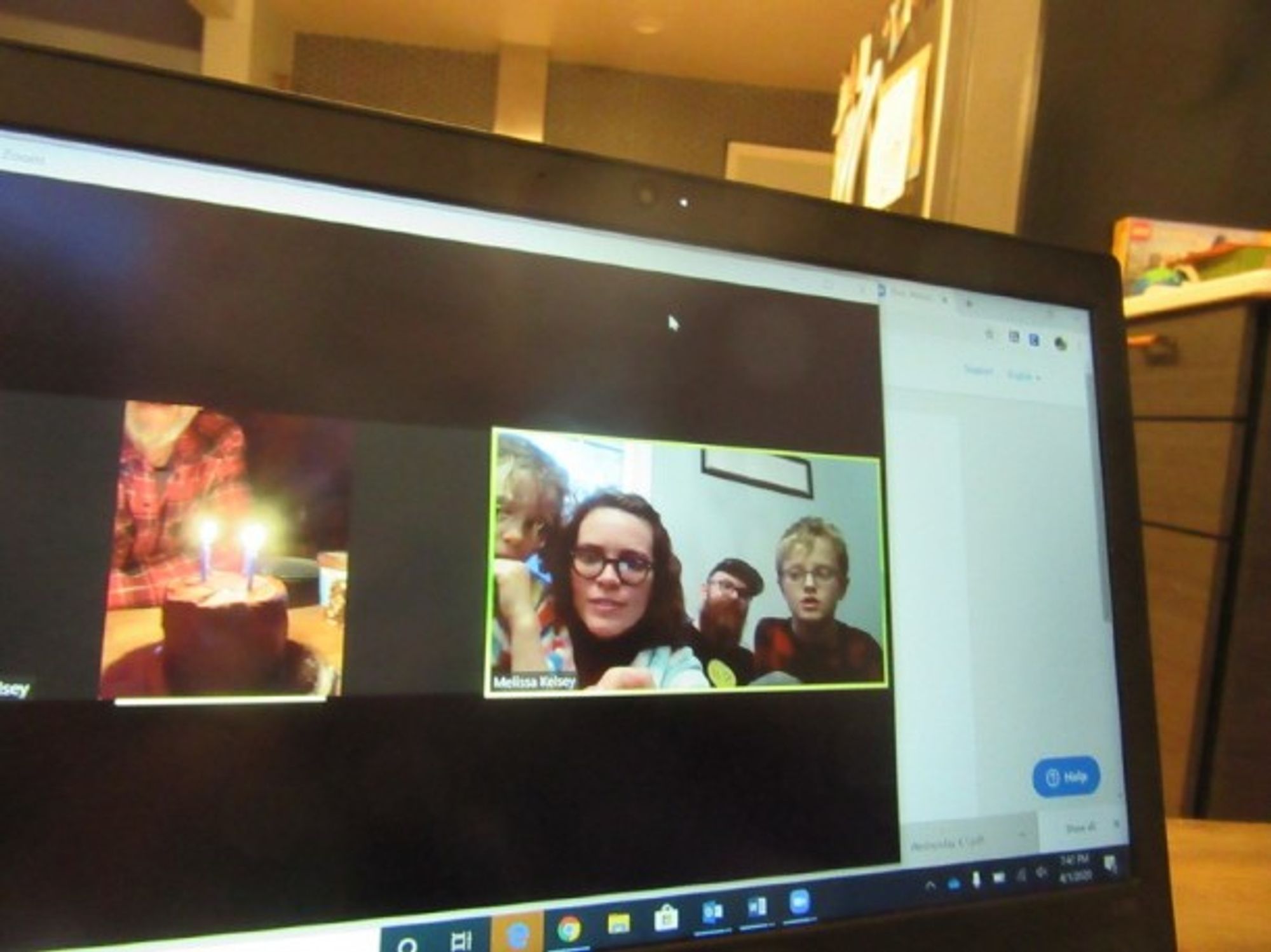 A family wishing happy birthday to their grandfather through video call.