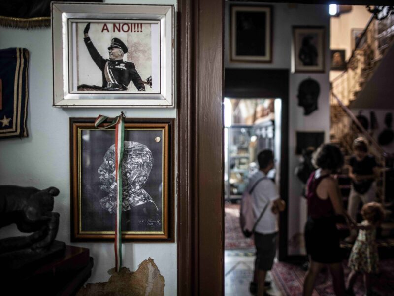 A Fascist poster hangs on a wall inside ​Benito Mussolin's former home in Forli, Italy