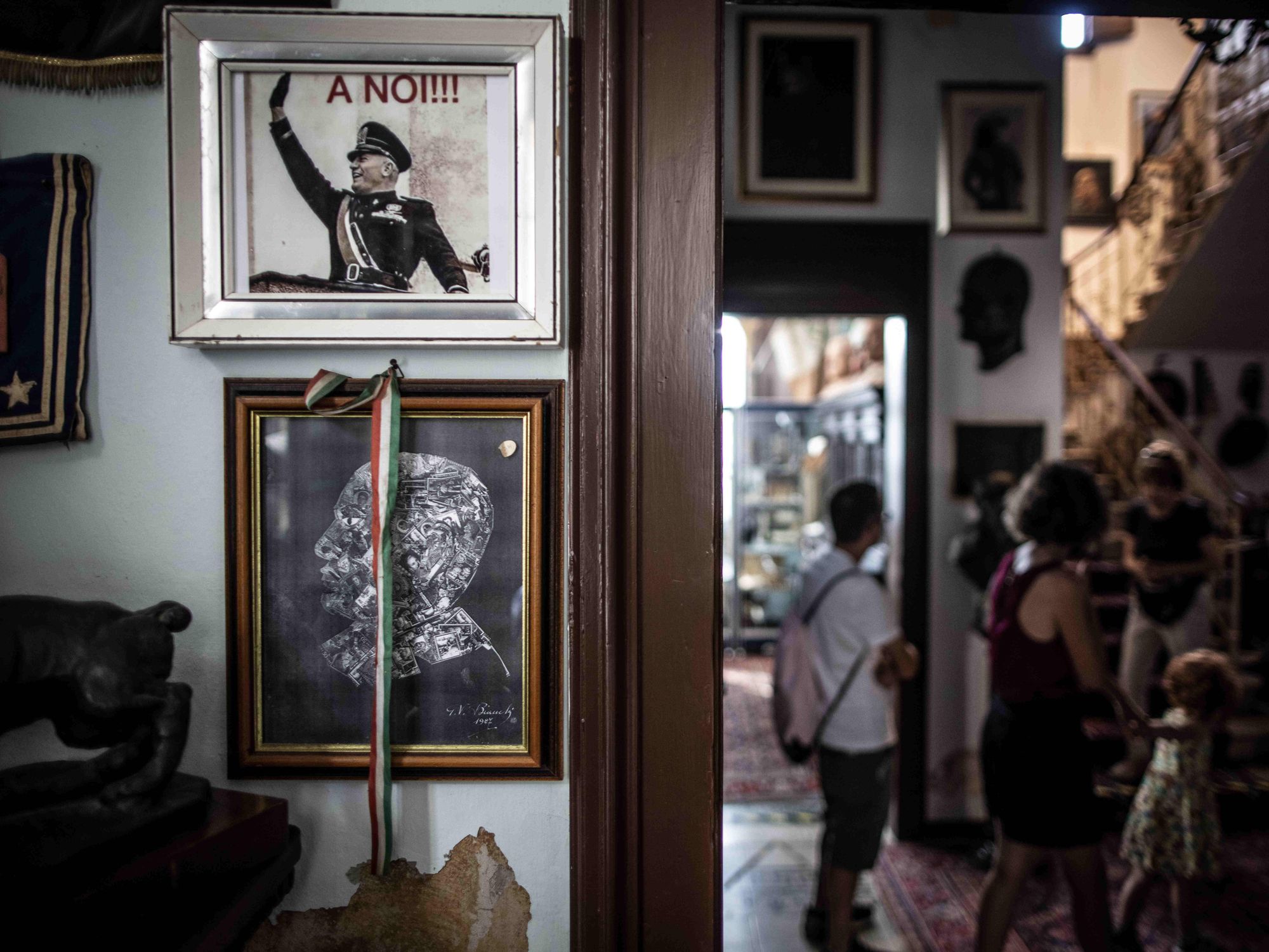 A Fascist poster hangs on a wall inside ​Benito Mussolin's former home in Forli, Italy
