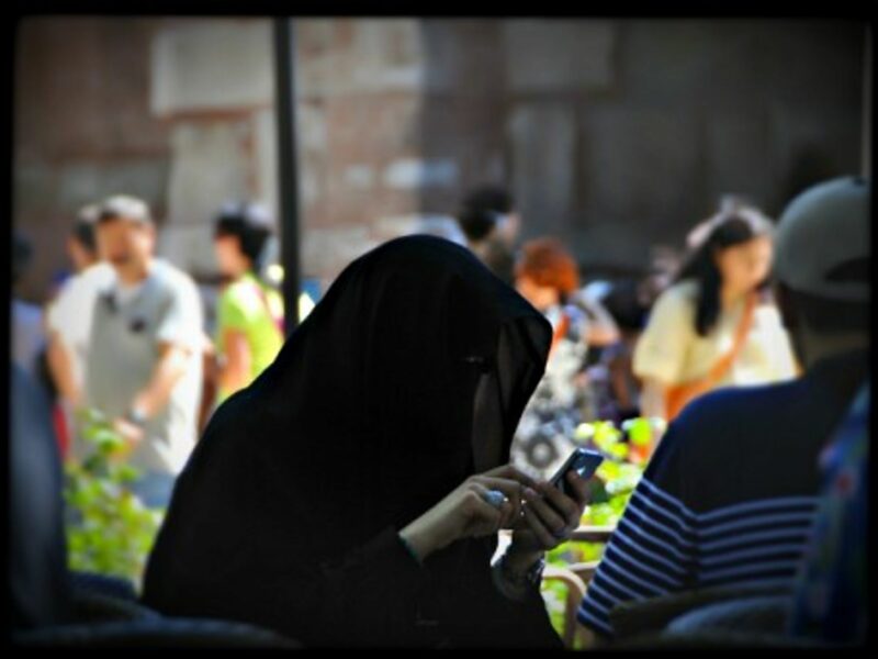 A fully veiled woman using her smartphone in Istanbul