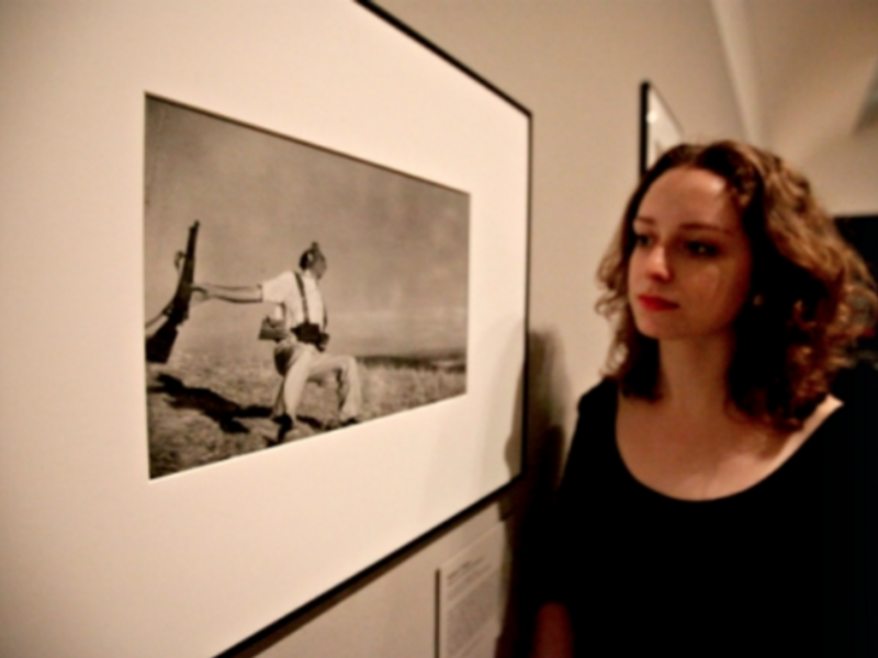A gallery assistant looks at Robert Capa's