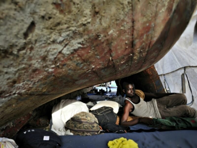 A Gambian migrant living under an boat outside Tripoli, Libya