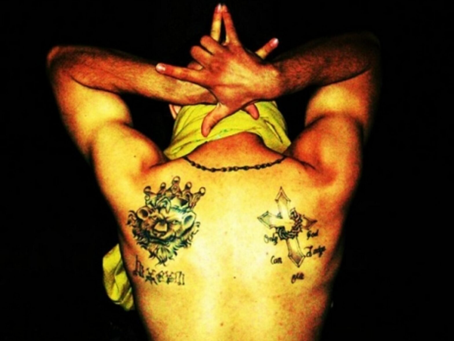 A gang member showing off his tattoos