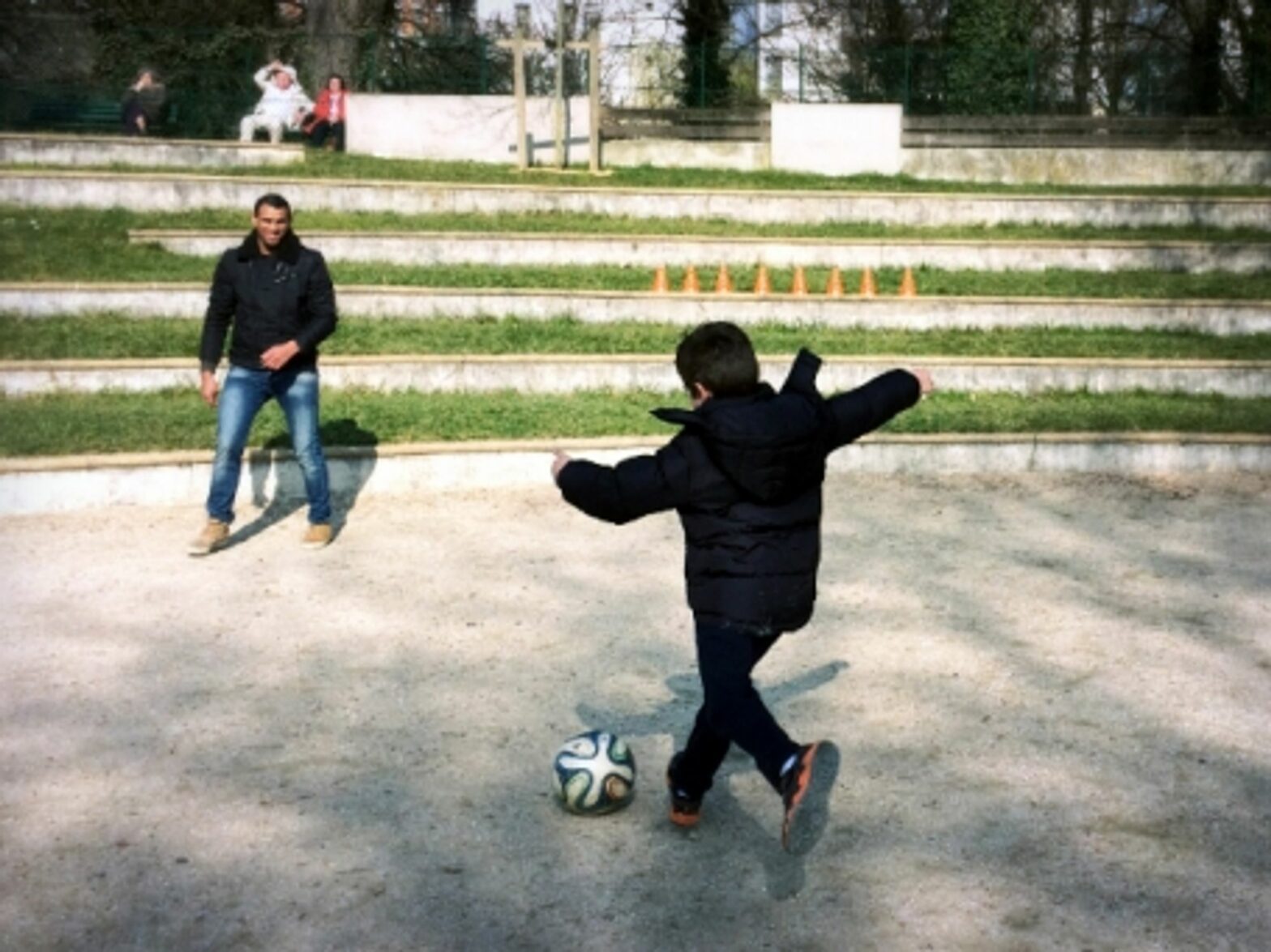 A Garrigan boy playing soccer with a Syrian refugee in Paris' Parc Sainte-Perrine