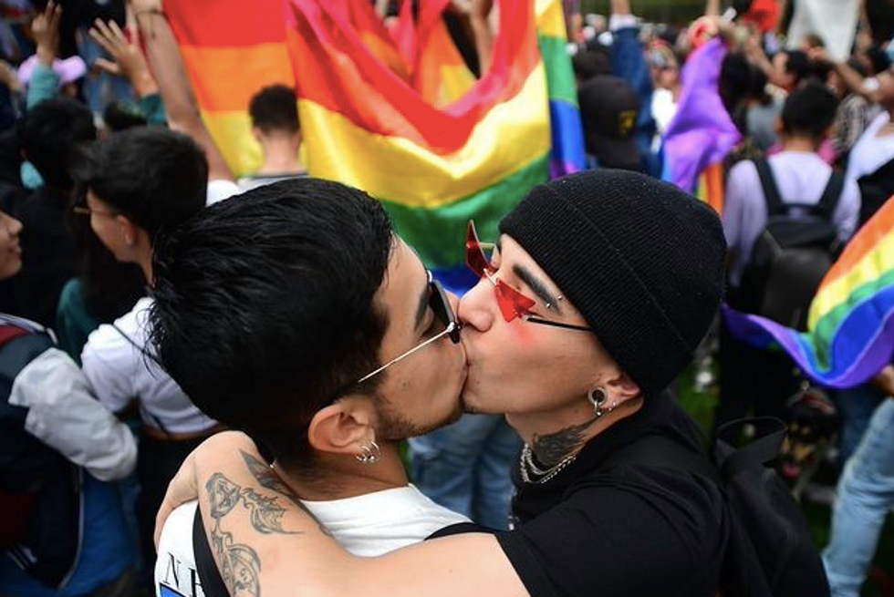 A gay couple kisses in public as part of the "Besatón" in Colombia​