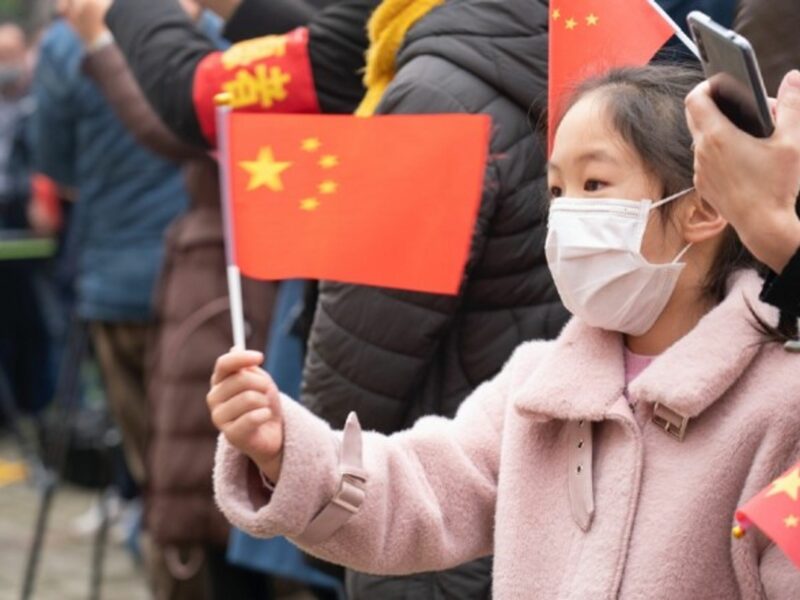 A girl waves a Chinese flag while seeing off visiting medics from in Wuhan on Monday.