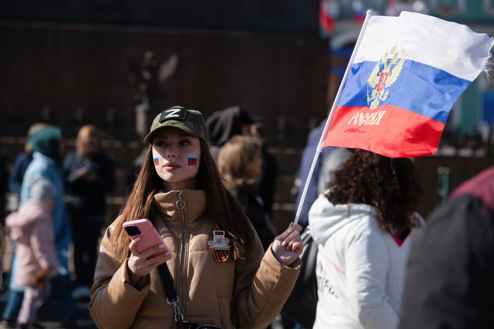 A girl with the ''Z'' symbol holds the Russian flag during the celebration of Victory Day.