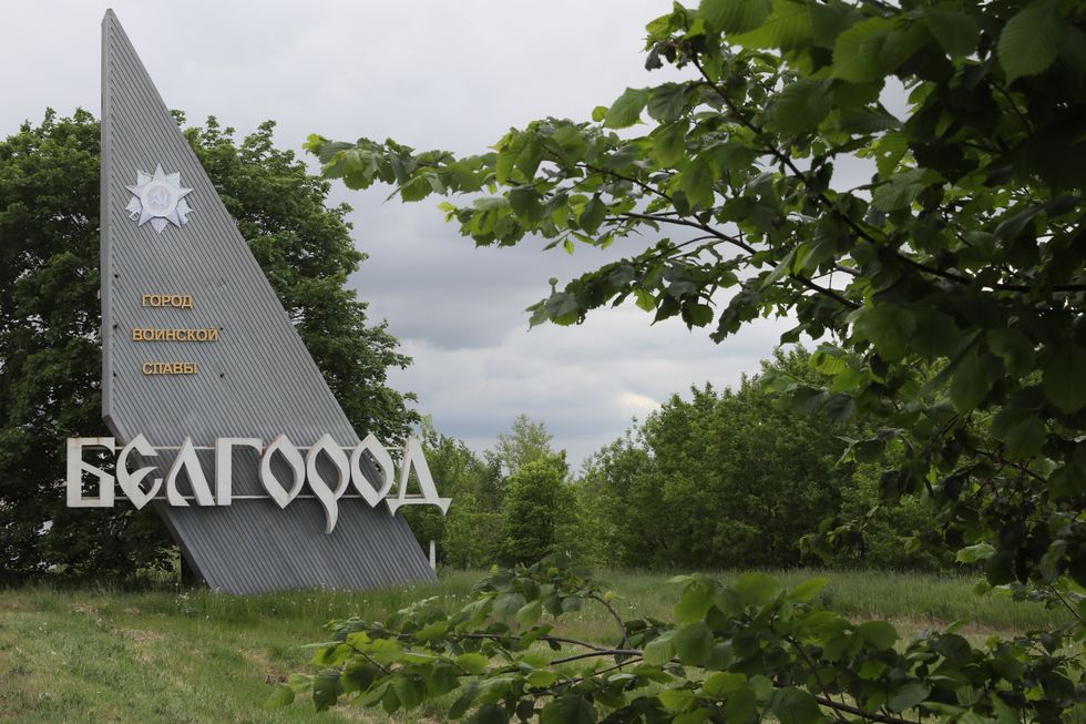 A grey monument stands among the greenery at an entrance to Belgorod