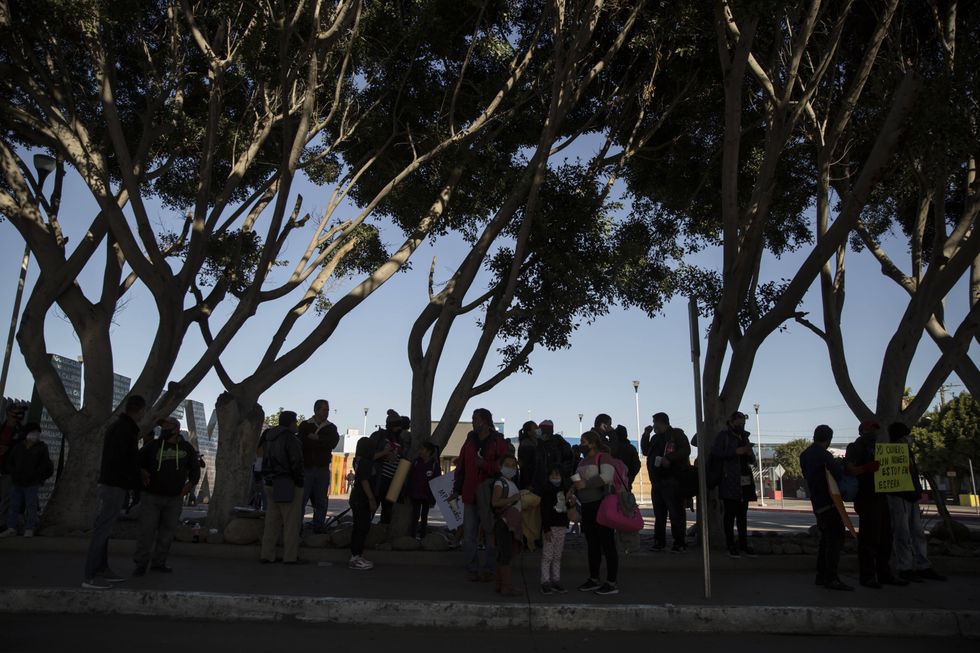 A group of migrants gather in a plaza near the border crossing just before their protest begins.