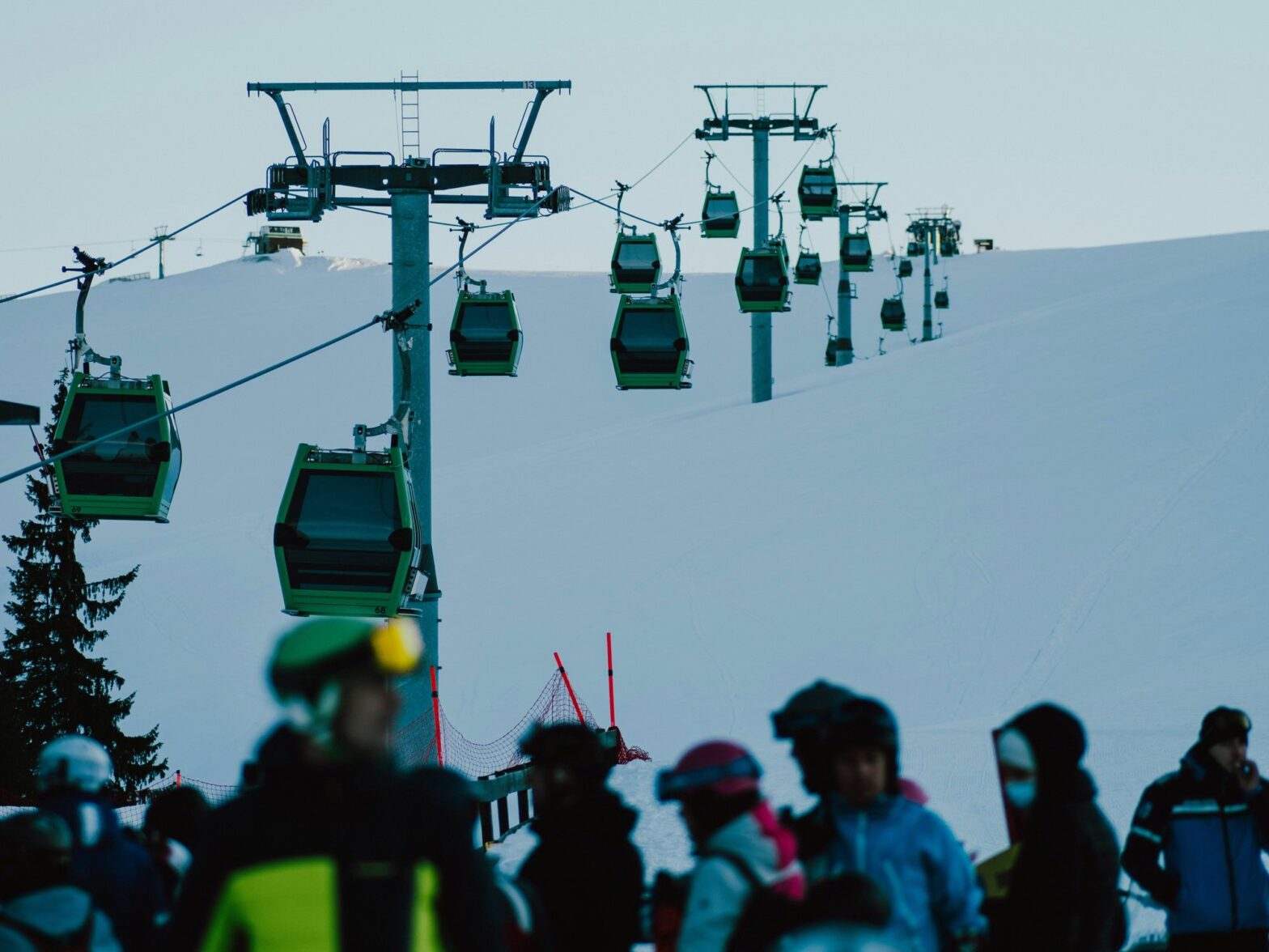 A group of people riding skis down a snow covered slope.