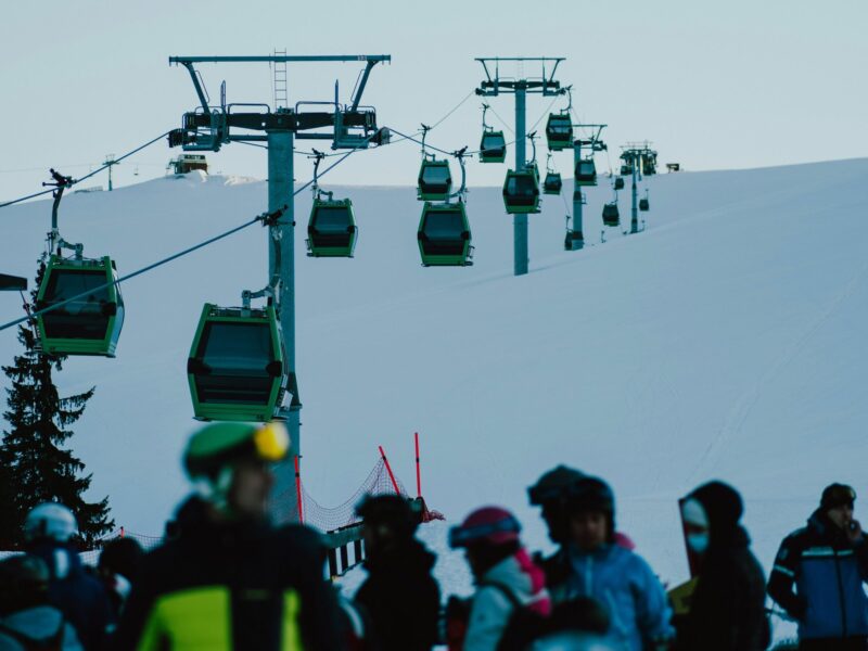 A group of people riding skis down a snow covered slope.