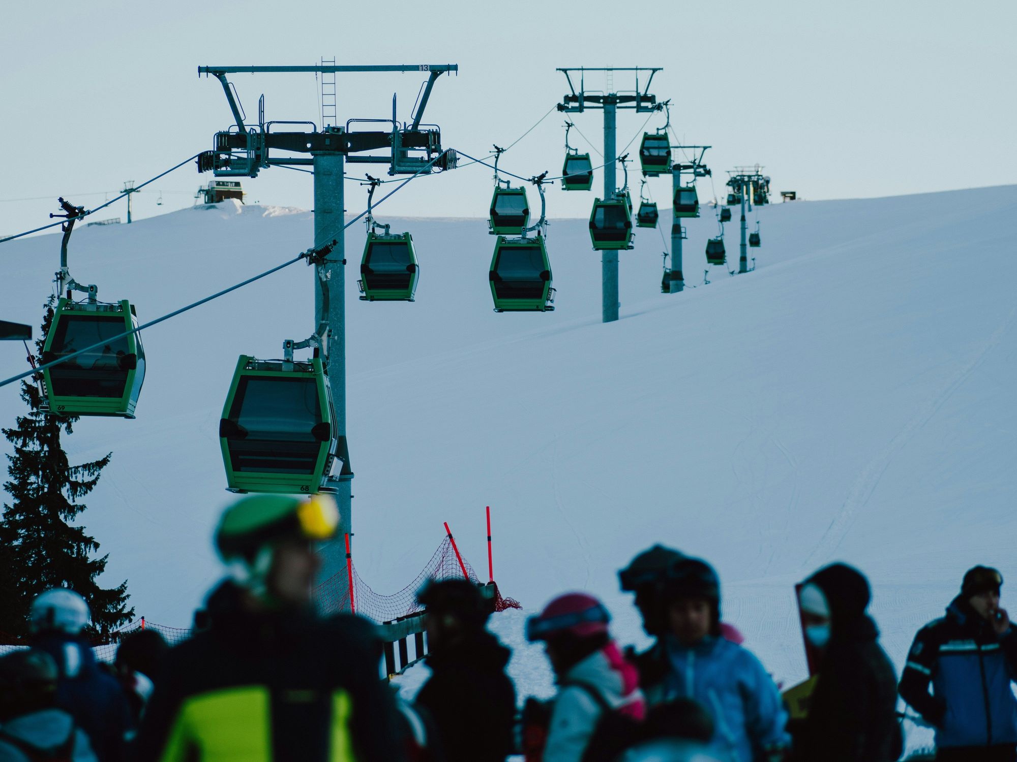 A group of people riding skis down a snow covered slope.