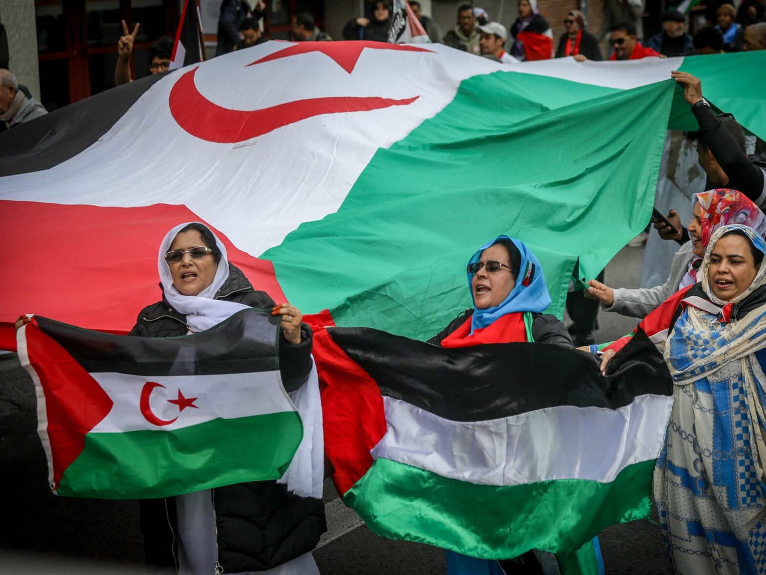 A group of Sahrawi women protesters carry flags of Western Sahara and Palestine during a pro-Sahrawi demonstration in the center of Madrid.