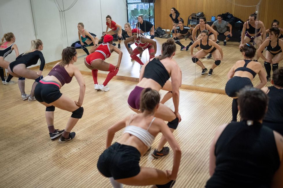 A group of women learning who to Twerk in a dance class, taking place in Paris, France.