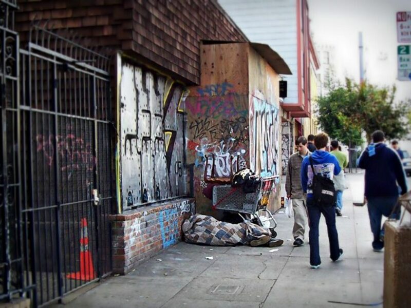 A homeless person resting on Church Street in San Francisco, California