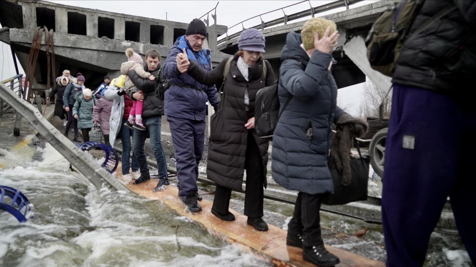 A line of Ukrainian fleeing the country through Irpin checkpoint