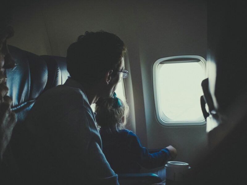 A Man and girl sitting inside an airplane during daytime