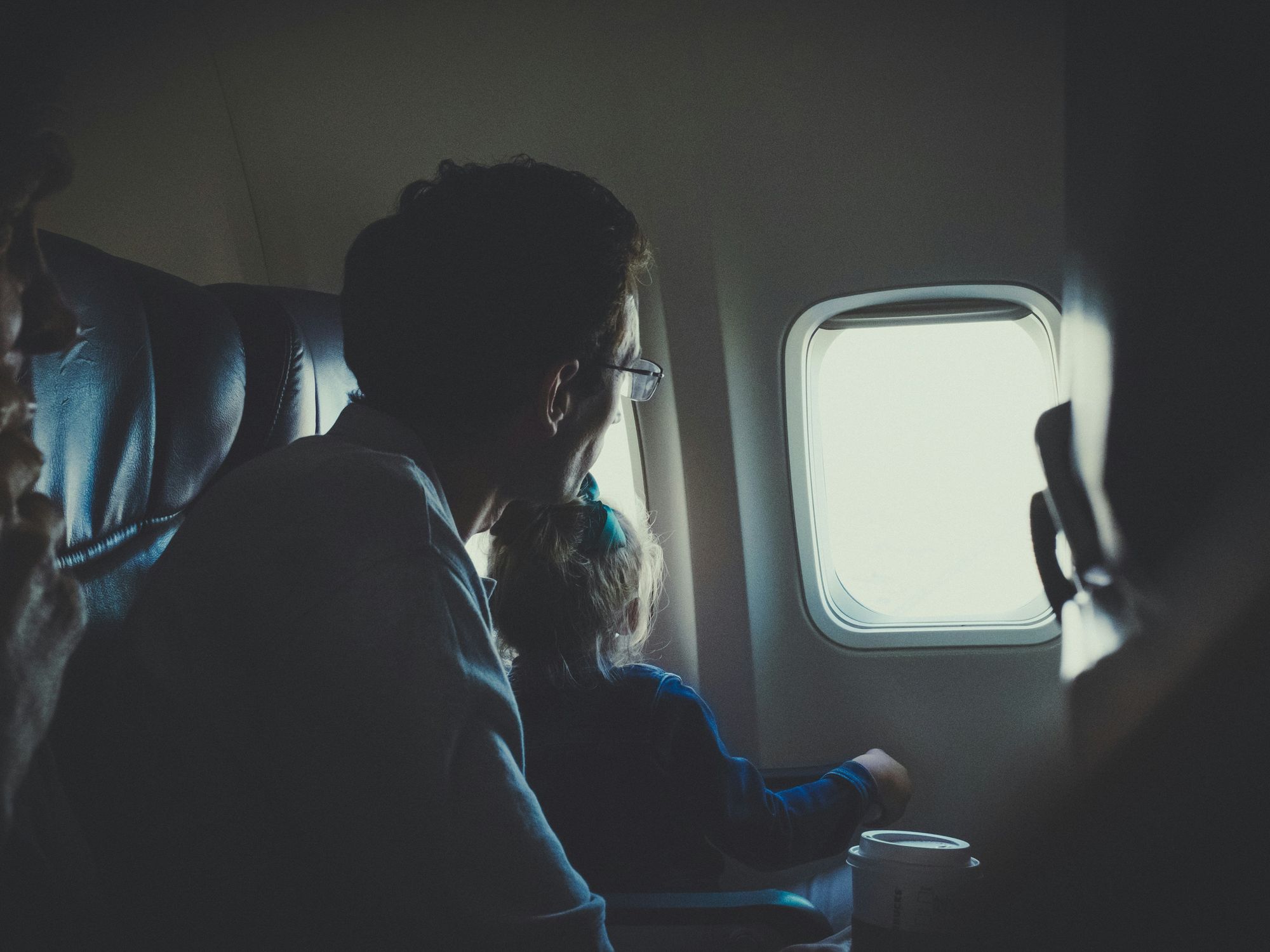 A Man and girl sitting inside an airplane during daytime