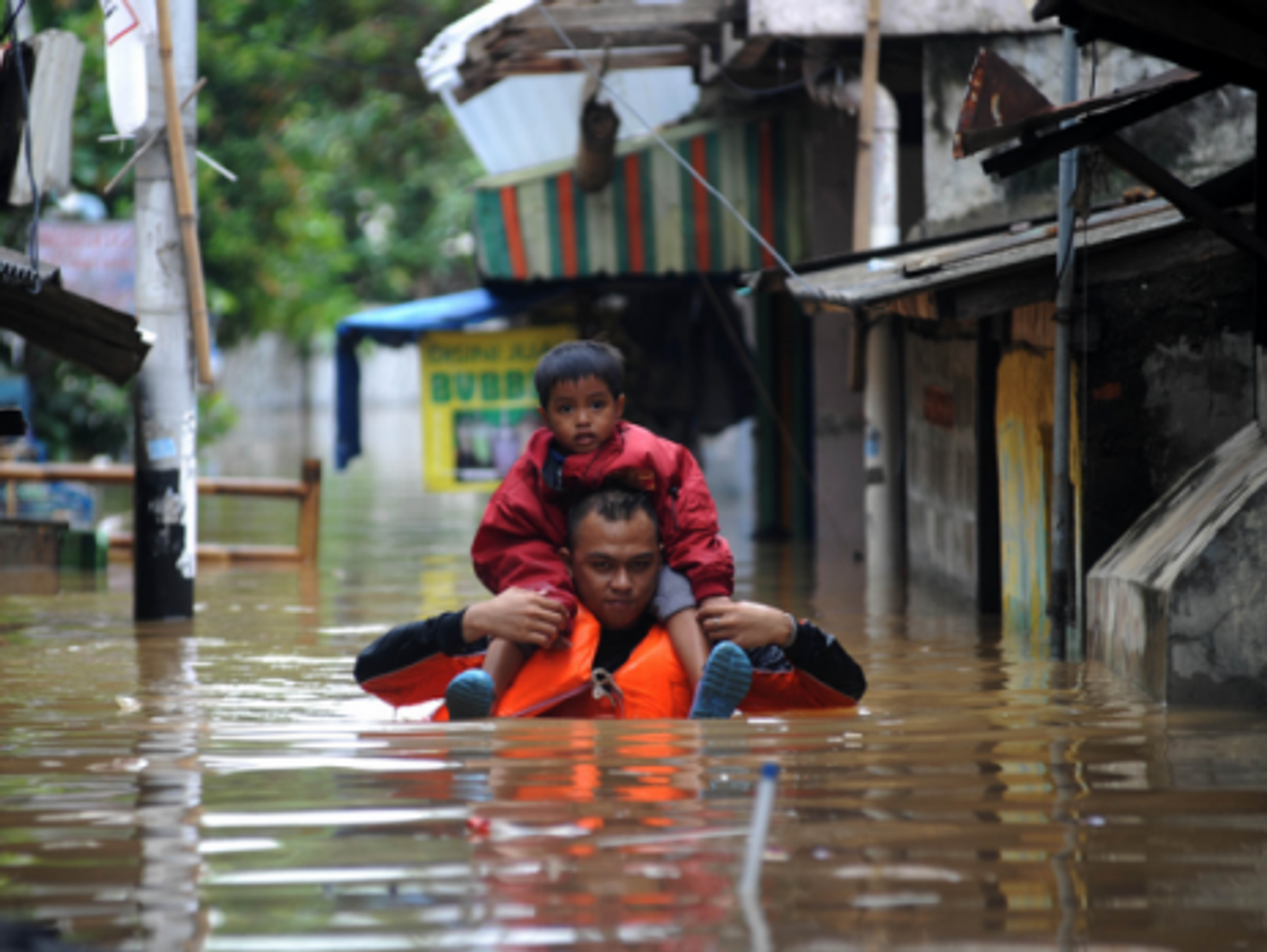 A man carries a child in the floodwaters that have hit Jakarta this week.