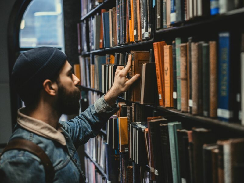 A man choosing a book in a library.