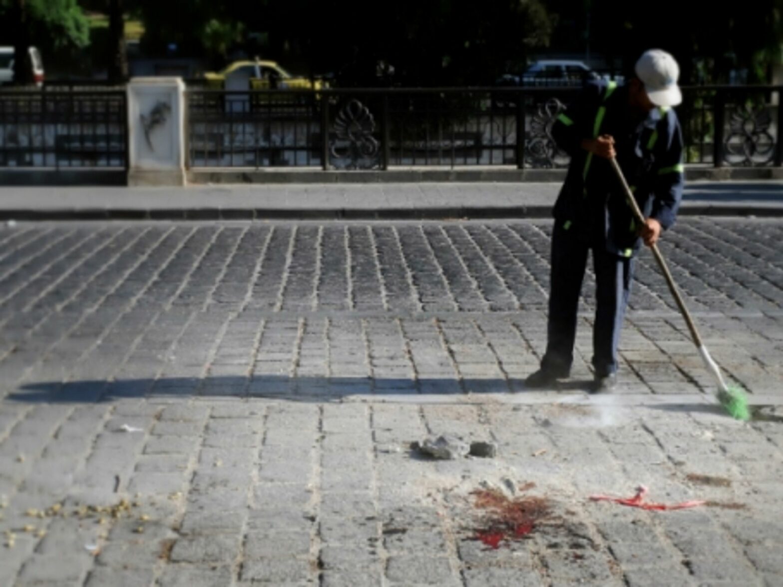 A man cleans blood from the site of an explosion in Damascus on Aug. 12