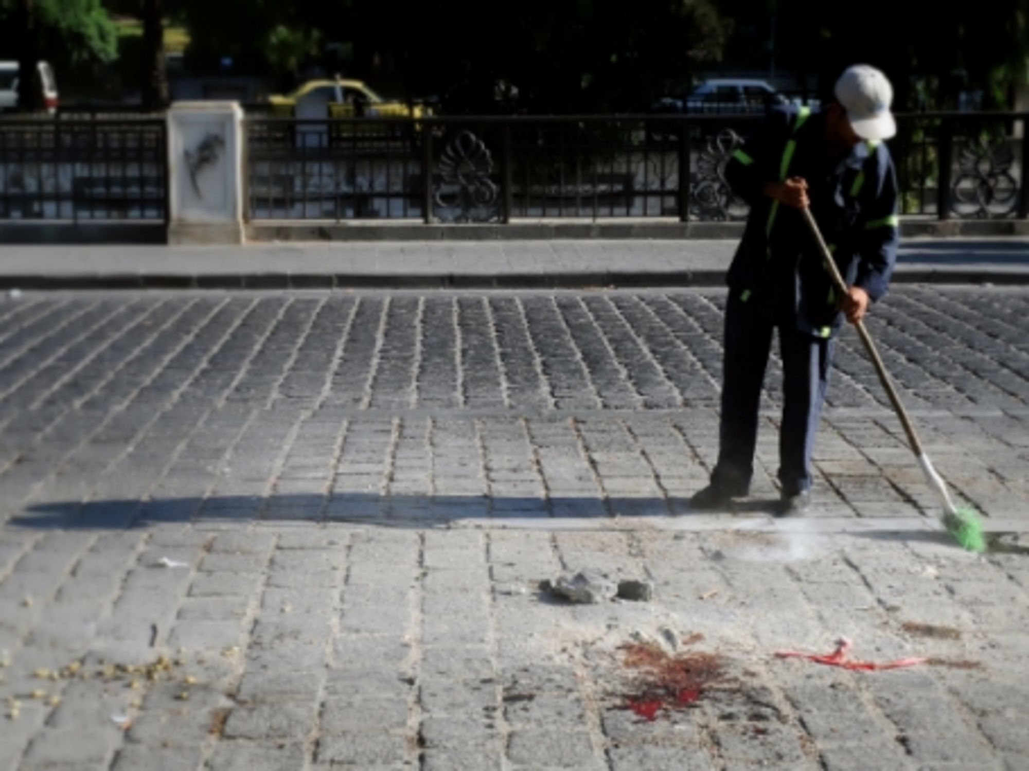 A man cleans blood from the site of an explosion in Damascus on Aug. 12