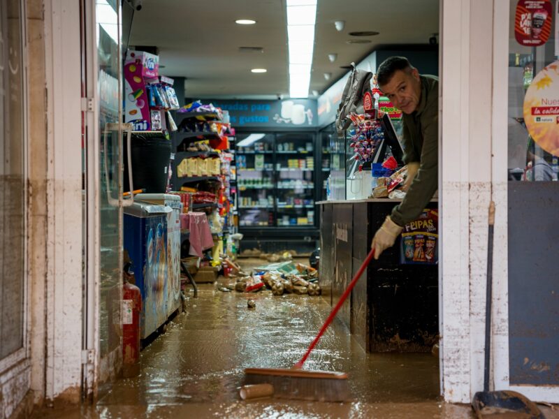 A man cleans his store from water and mud with a broom in Valencia, Spain after flash floods desecrated the city.