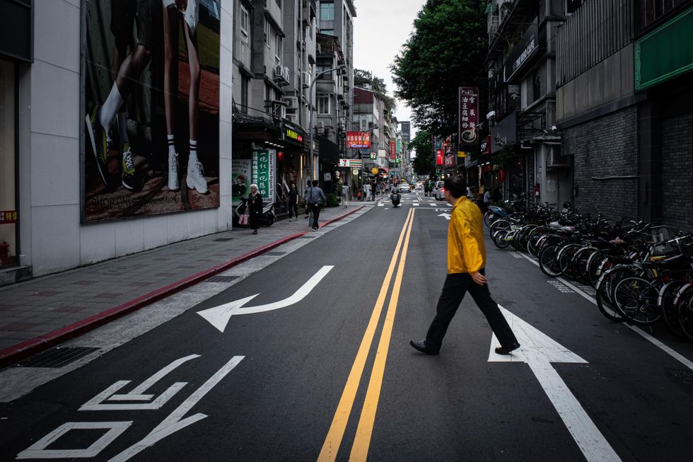 A man crosses the street in Taipei, Taiwan.
