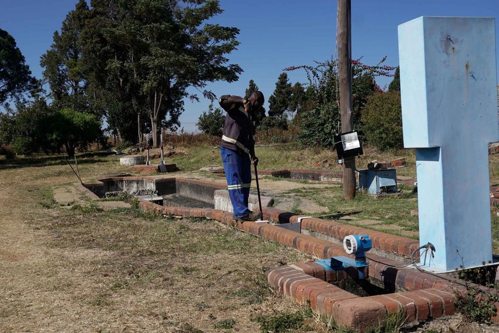A man does maintenance on the Norton sewage treatement system.
