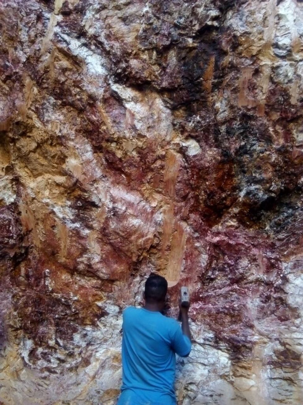 A man extracting gold in a mine.