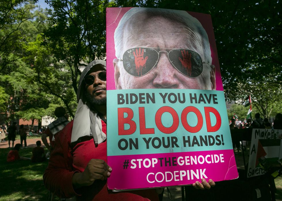 A man holding a sign calling on Joe Biden to "stop the genocide" during a rally of thousands of pro-Palestinian demonstrators in front of the White House in June 2024.