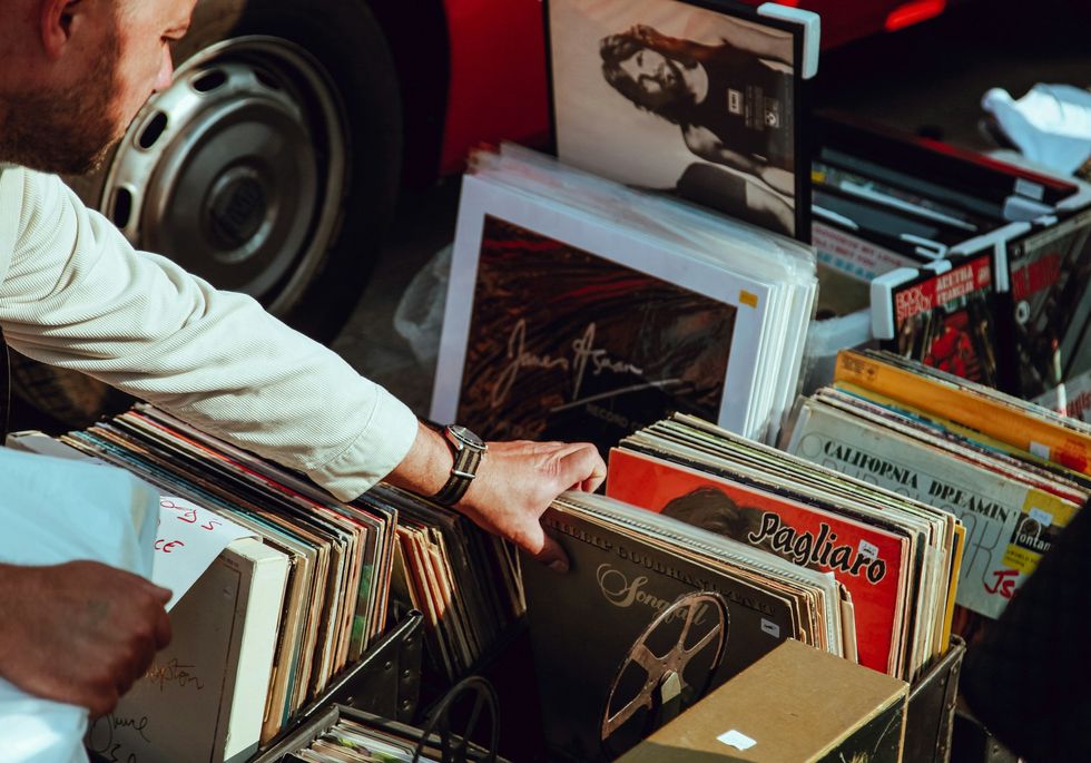 a man looking at vinyls during a car boot sale