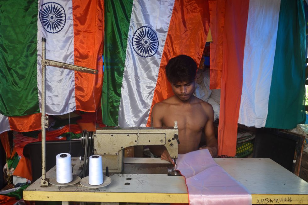 A man manufacturing an Indian flag at flag making workshop.