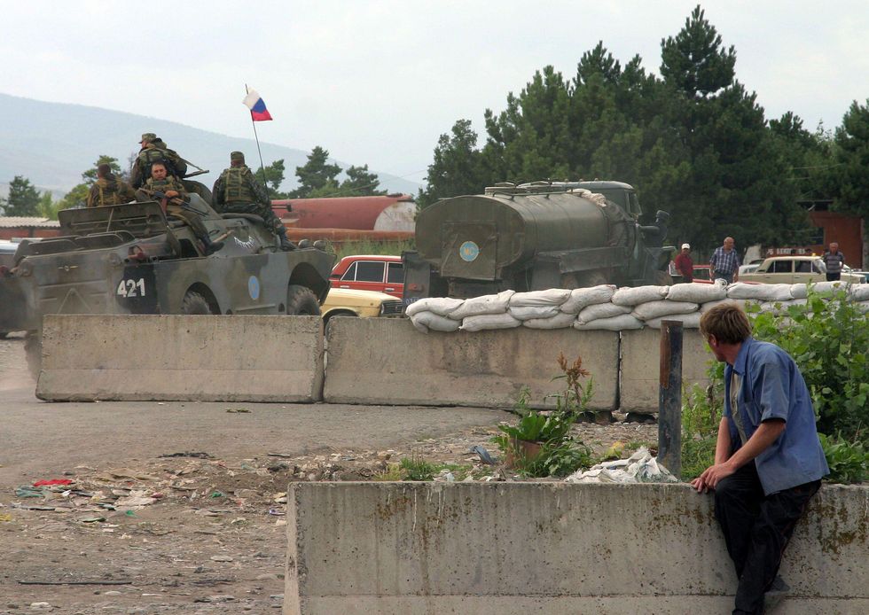 A man observes Russian peace-keeping forces in Ergneti, South Ossetia.