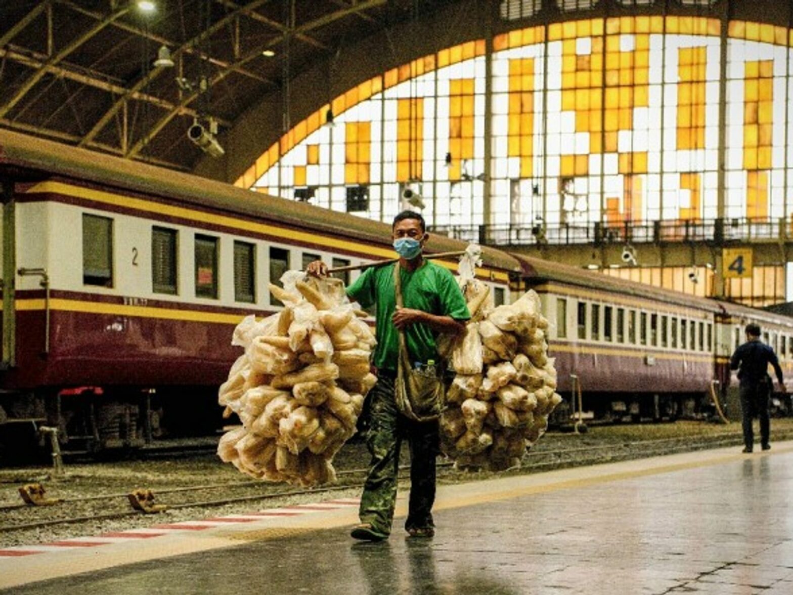 A man passes train wagons parked at Hua Lamphong railway station in Bangkok, Thailand