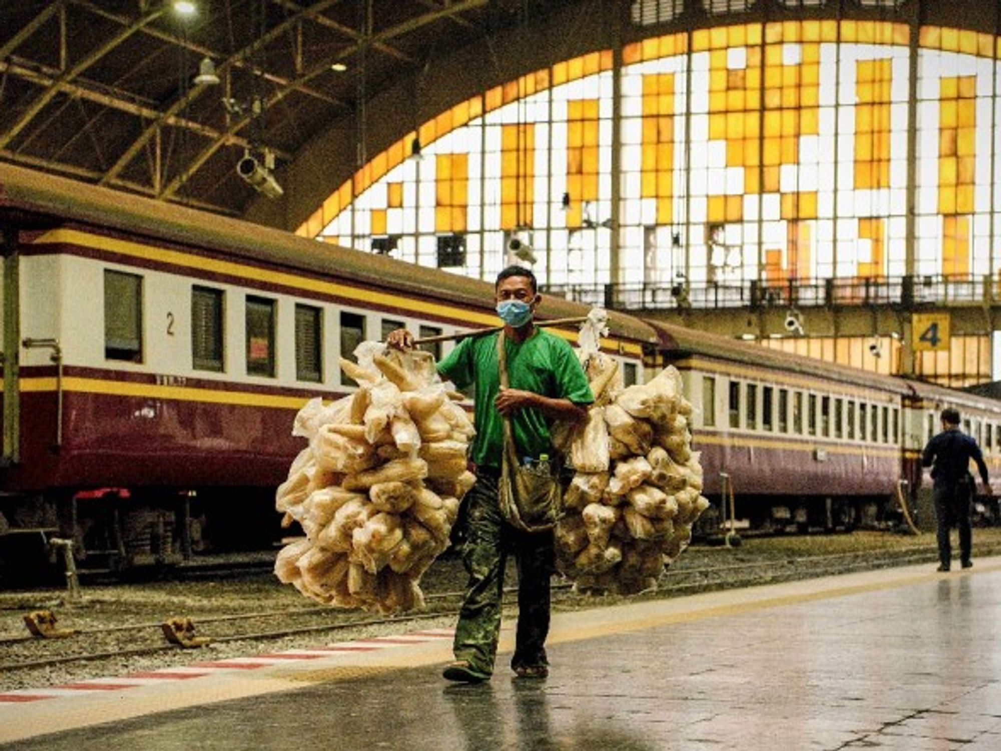 A man passes train wagons parked at Hua Lamphong railway station in Bangkok, Thailand