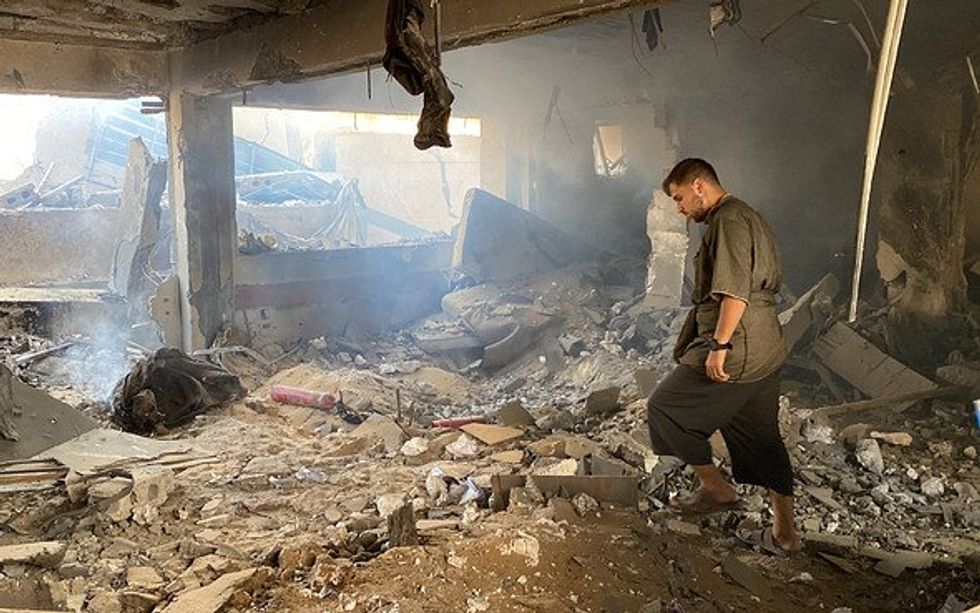 A man searching through rubble