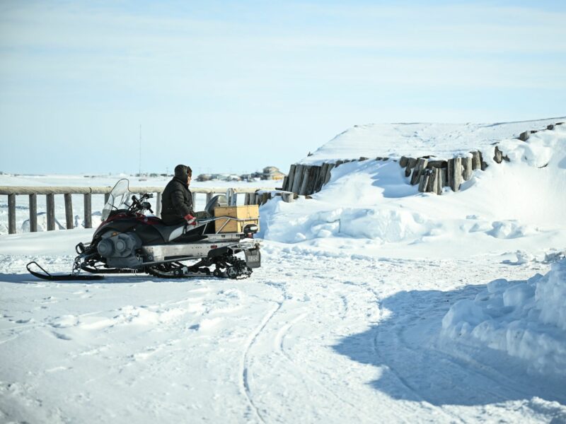 A man sits on his snowmobile in Tuktoyaktuk in the Arctic