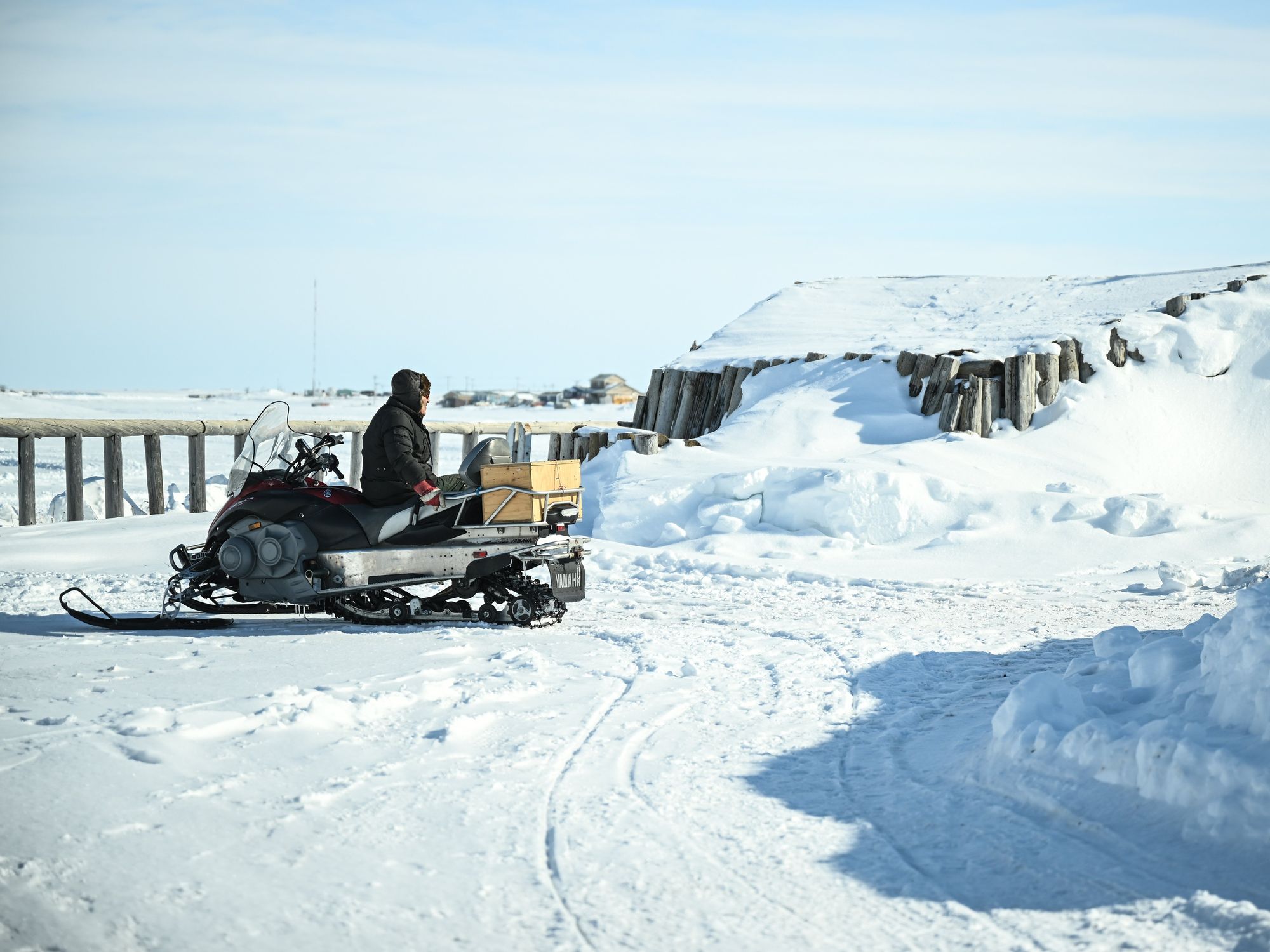 A man sits on his snowmobile in Tuktoyaktuk in the Arctic