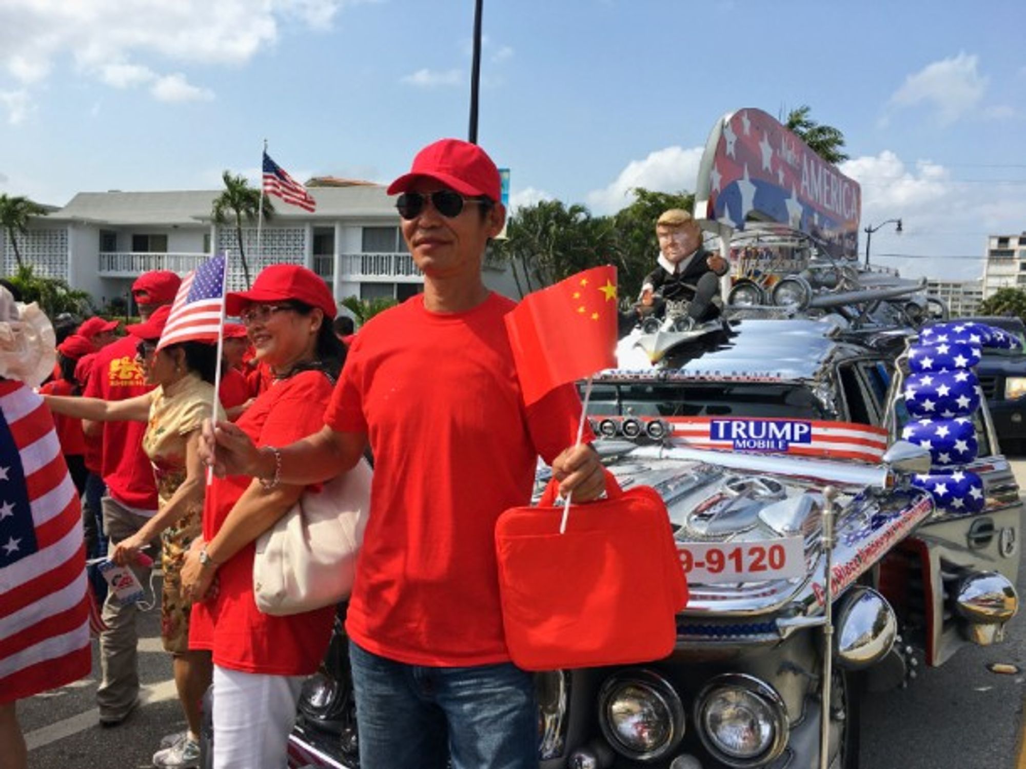 A man stands with hundreds of other Chinese activists to rally in support of Trump in Lantana, Florida.