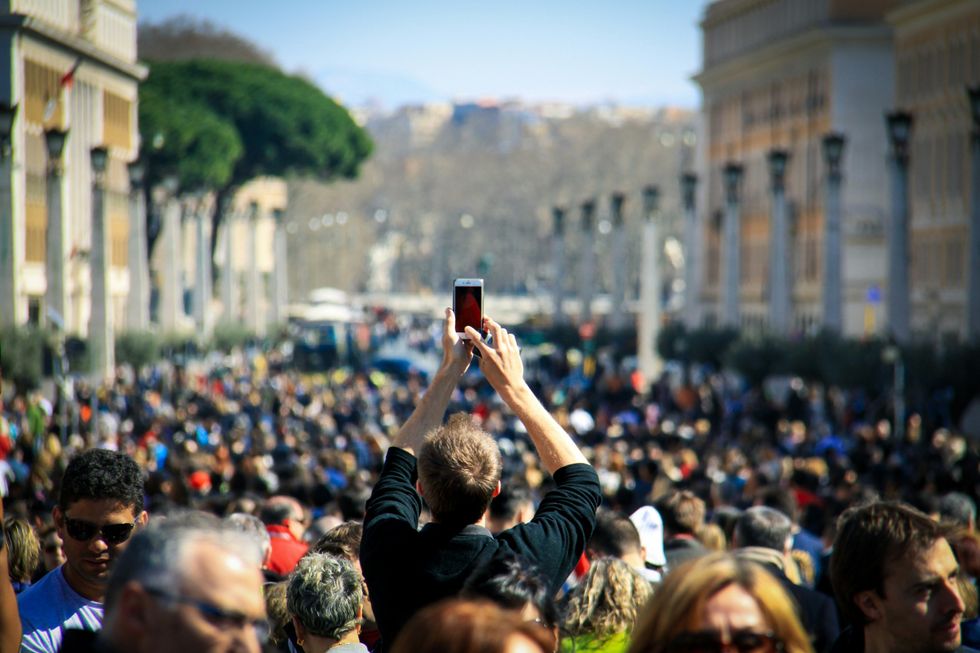 A man takes a picture with a smartphone in Vatican City.