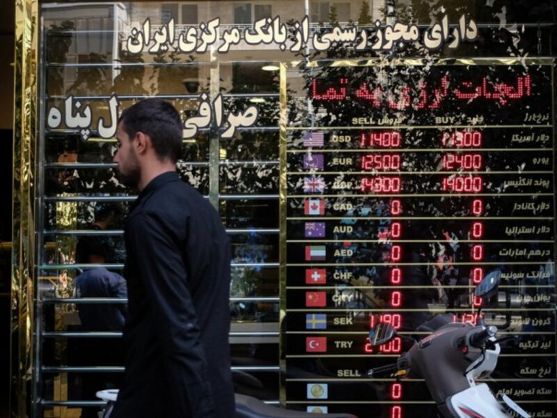 A man walking past a currency exchange shop in Tehran