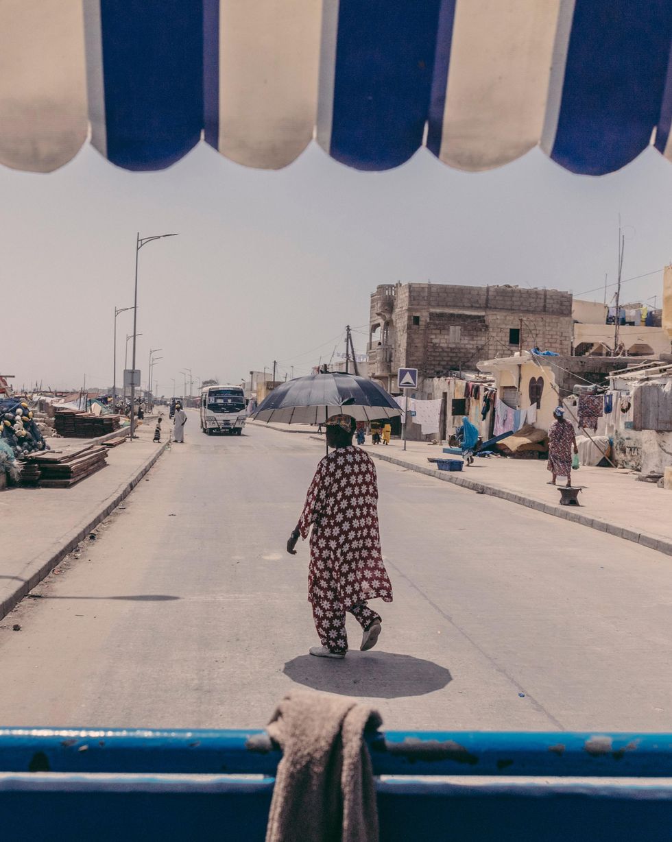 A man walking with an umbrella in Saint Louis, Senegal