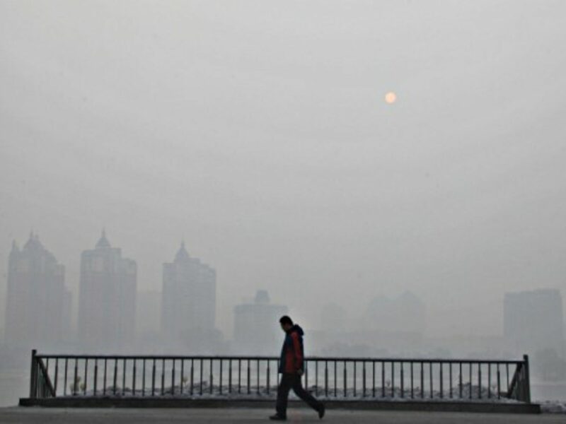 A man walks in a fog-shrouded city in northeast China's Jilin Province, in February 2014.