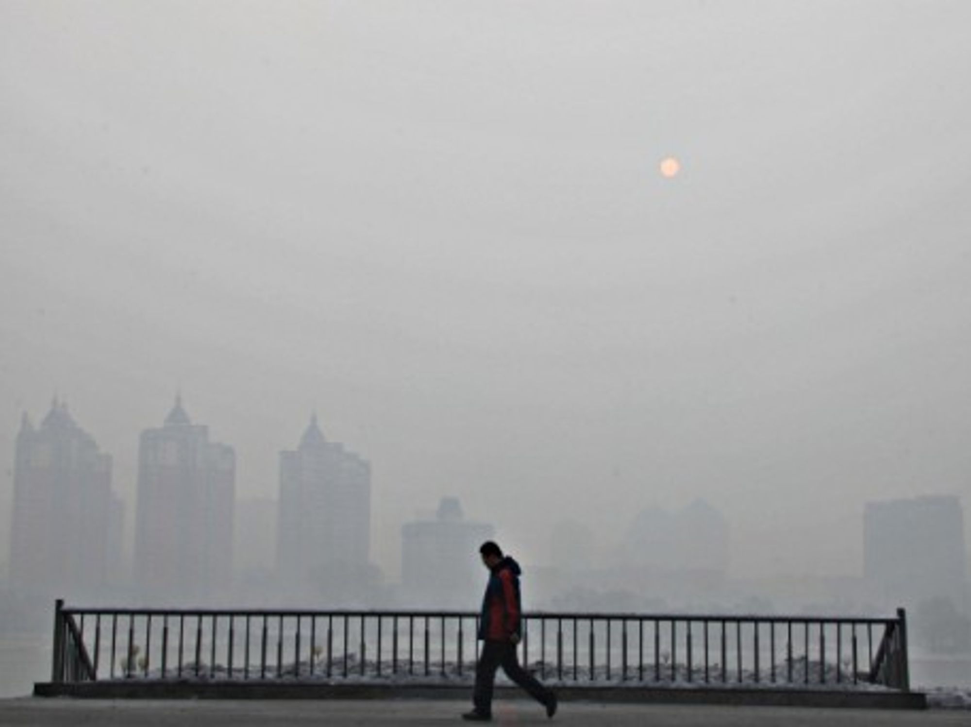 A man walks in a fog-shrouded city in northeast China's Jilin Province, in February 2014.