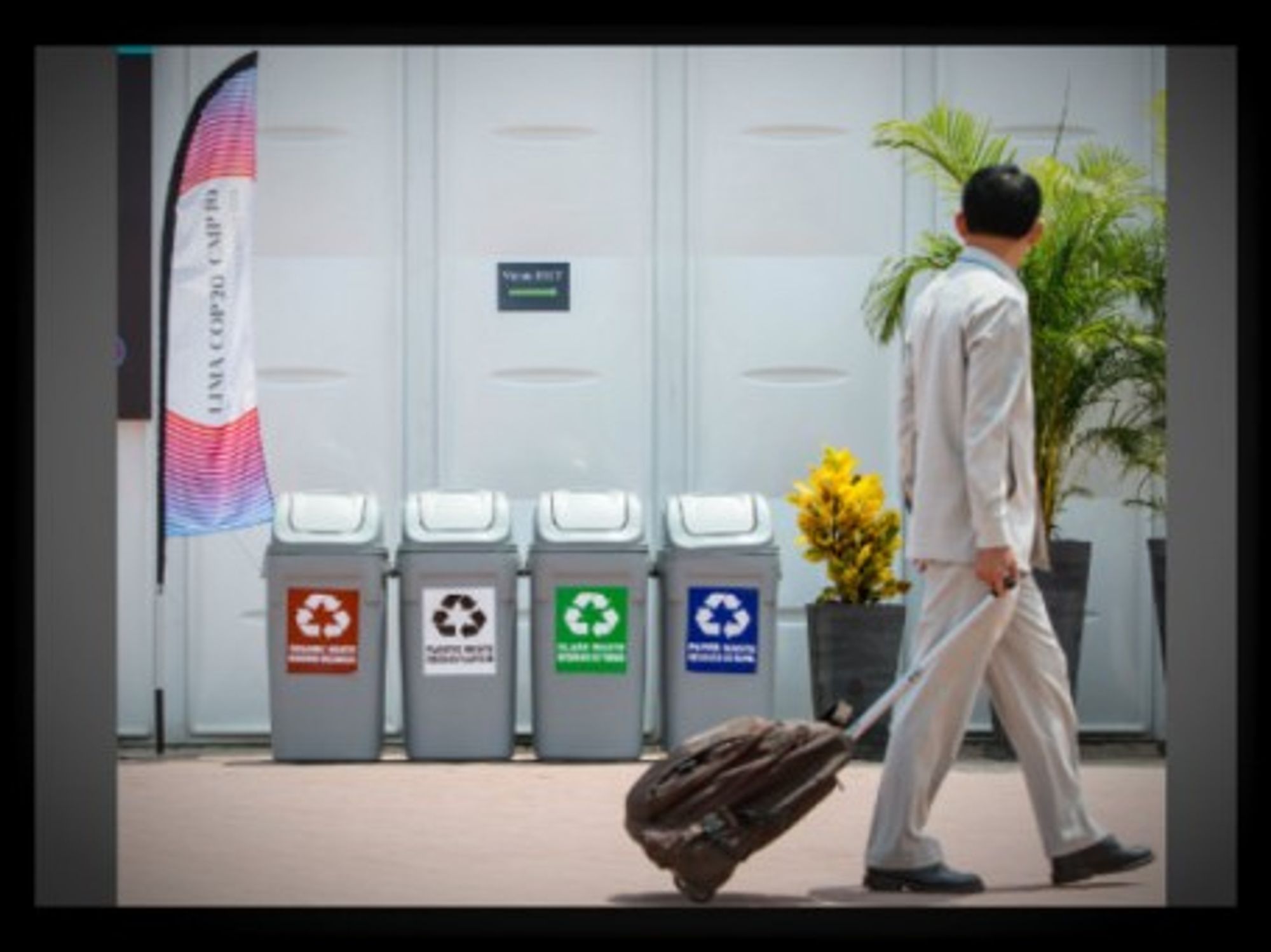 A man walks past recycling bins next to the COP 20 conference center in Lima on Dec. 3