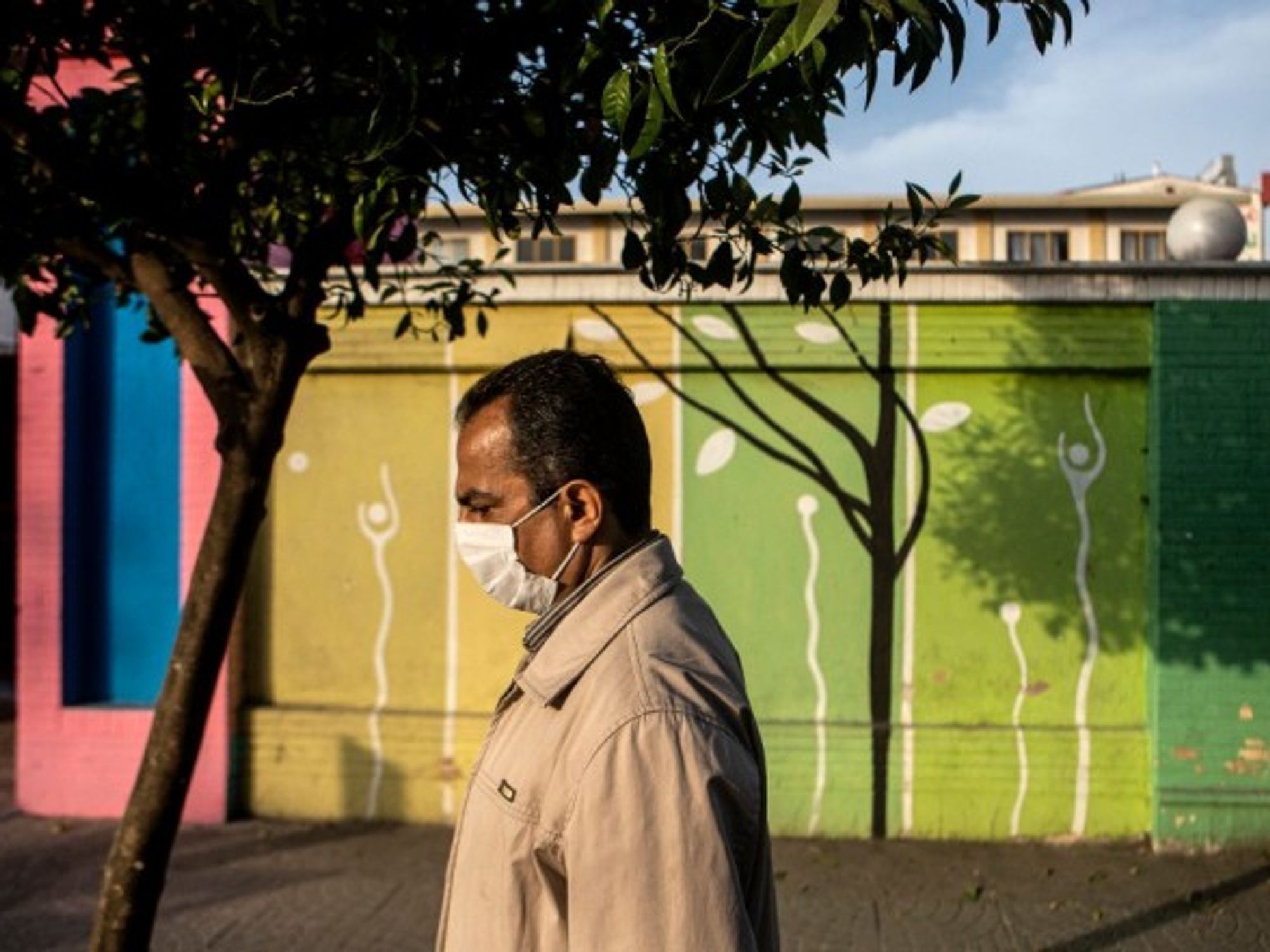 A man wearing a face mask walks on a street in Tonekabon, Iran, on April 26, 2021.