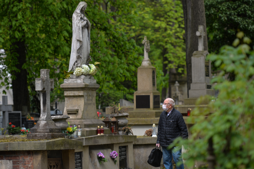 A man wearing a protective mask seen in Krakow's Rakowicki cemetery