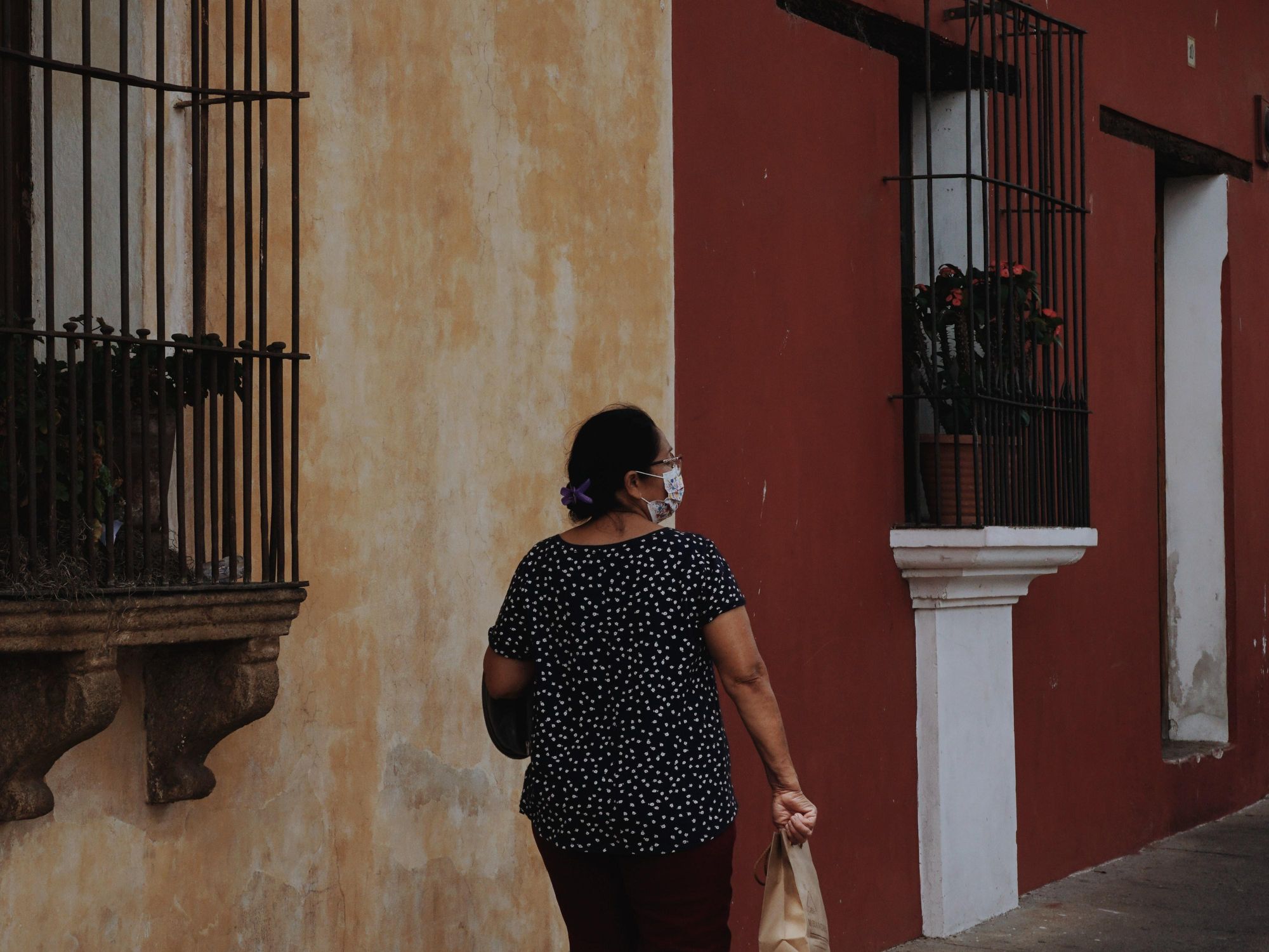 A masked woman seen from behind.
